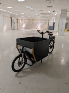 A cargo bike parked inside a large white room